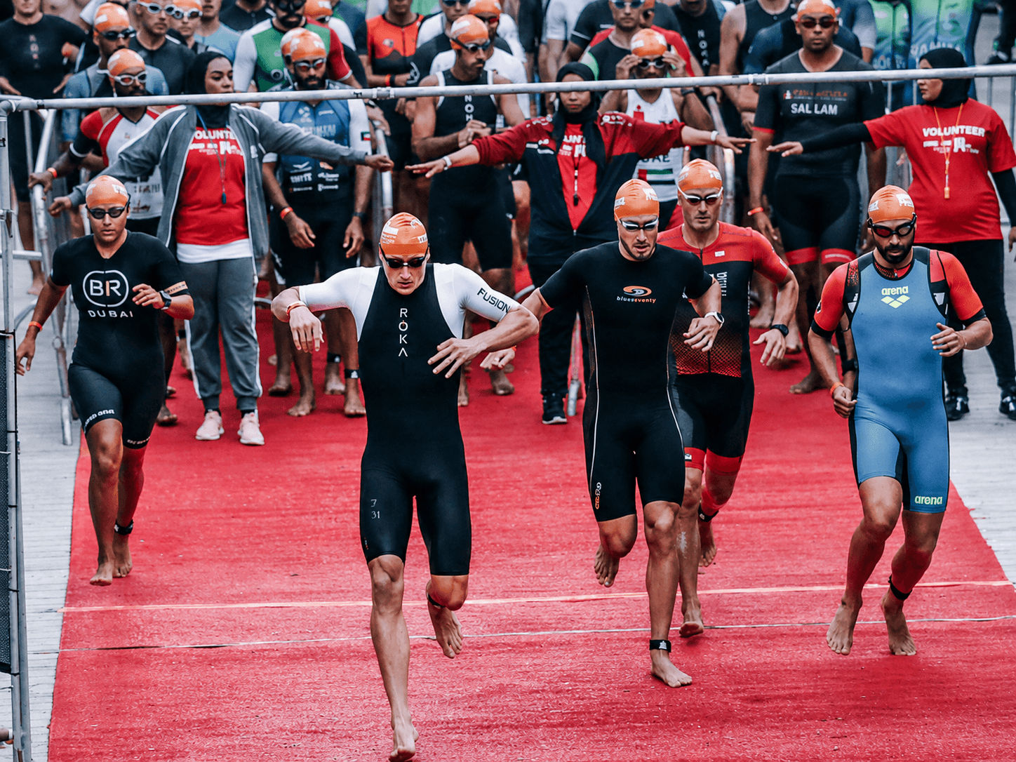 Triathletes running to the swim start for the swim time breakdown